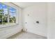 Bright laundry room with white walls, tiled floors and a large window for natural light at 6401 N Central Ave, Tampa, FL 33604