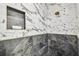 Close-up of a luxurious shower with marble tile and a built-in niche for toiletries at 6401 N Central Ave, Tampa, FL 33604