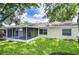 Backyard with a screened-in porch and lush green lawn at 6720 Gilda Dr, Tampa, FL 33625