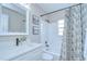 Bathroom featuring modern fixtures, a tiled shower-tub, and a decorative mirror with complimentary artwork at 6720 Gilda Dr, Tampa, FL 33625