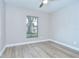 Simple bedroom featuring a large window providing natural light and wood-look flooring at 6720 Gilda Dr, Tampa, FL 33625