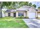 Charming single-Gathering home featuring an attached garage and well-maintained landscaping at 6720 Gilda Dr, Tampa, FL 33625