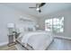 Comfortable bedroom with a large window, ceiling fan, neutral decor, and stylish furnishings at 6720 Gilda Dr, Tampa, FL 33625