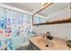 Nautical-themed bathroom with bright blue decor, a white vanity, and a decorative shower curtain at 7631 Ironbark Dr, Port Richey, FL 34668
