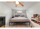 Cozy bedroom with cross, ceiling fan, and a comfortable bed featuring metal frame and neutral bedding at 7631 Ironbark Dr, Port Richey, FL 34668