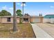 Charming single-story home with a well-maintained lawn and an American flag displayed out front at 7631 Ironbark Dr, Port Richey, FL 34668