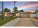 Charming single-story home with a well-maintained lawn, two palm trees, and an American flag displayed out front at 7631 Ironbark Dr, Port Richey, FL 34668