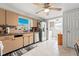 A well-lit kitchen featuring light colored cabinets, stainless steel appliances, a ceiling fan, and tile flooring at 7631 Ironbark Dr, Port Richey, FL 34668