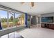 A living room with a large window, a TV, tile floors, and view into the entry of the home at 7631 Ironbark Dr, Port Richey, FL 34668