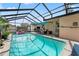 Backyard oasis with screened-in pool, patio area, and lush greenery at 7631 Ironbark Dr, Port Richey, FL 34668