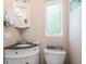 Half bath featuring a white vanity with black countertop, toilet and frosted glass window at 7802 134Th St, Seminole, FL 33776