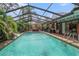 Large screened pool surrounded by tropical plants and patio furniture for entertaining at 7802 134Th St, Seminole, FL 33776