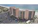 Aerial view of a condo building, parking area, and beach at 880 Mandalay Ave # C513, Clearwater Beach, FL 33767