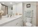 Bright bathroom features a large mirror, updated vanity with white countertops and white cabinets, and a toilet at 880 Mandalay Ave # C513, Clearwater Beach, FL 33767
