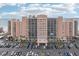 Front of tan condo building with beach view; wide parking lot in front at 880 Mandalay Ave # C513, Clearwater Beach, FL 33767