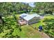 Aerial view of the home featuring a deck, fenced yard and large trees surrounding the property at 9448 Mcintyre Rd, Brooksville, FL 34601
