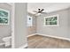 Stylish bedroom featuring an exposed brick wall, ceiling fan, and light-filled windows at 9448 Mcintyre Rd, Brooksville, FL 34601