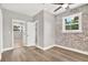 Stylish bedroom featuring an exposed brick wall, ceiling fan, and access to bathroom and closet at 9448 Mcintyre Rd, Brooksville, FL 34601