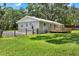 Exterior of the home featuring a back porch, fenced yard and mature trees at 9448 Mcintyre Rd, Brooksville, FL 34601