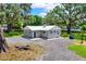 Charming single-story home with a new metal roof, gray paint, and a spacious gravel driveway at 9448 Mcintyre Rd, Brooksville, FL 34601