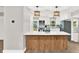 Modern kitchen island with white countertops, wood accents, and pendant lighting at 9448 Mcintyre Rd, Brooksville, FL 34601