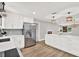 Modern kitchen features stainless steel appliances, white cabinetry, and a large center island at 9448 Mcintyre Rd, Brooksville, FL 34601