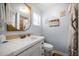 Bathroom with a white vanity, gold framed mirror, and beach-themed decor at 960 Gulf Blvd # 5, Indian Rocks Beach, FL 33785