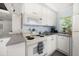 Efficient kitchen has white cabinets, tile floors, a microwave, and a dishwasher at 960 Gulf Blvd # 5, Indian Rocks Beach, FL 33785