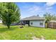Backyard features green lawn, fire pit, and screened-in pool area at 10457 Cranston St, Spring Hill, FL 34608