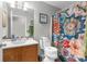 Cozy bathroom featuring a vanity, toilet, decorative shower curtain, and tiled walls at 10457 Cranston St, Spring Hill, FL 34608