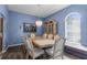Elegant dining room with stylish lighting, wainscoting details, and a large bay window seating area at 10457 Cranston St, Spring Hill, FL 34608