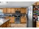 Close up of stainless steel oven and microwave in a kitchen with stainless steel refrigerator and tile backsplash at 10457 Cranston St, Spring Hill, FL 34608