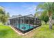 A screened pool surrounded by green lawn and landscaping at 10457 Cranston St, Spring Hill, FL 34608