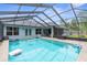 Screened-in pool with clear blue water, pool floats, and backyard access at 10457 Cranston St, Spring Hill, FL 34608
