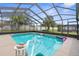 Beautiful screened pool with tropical landscaping and blue skies at 10457 Cranston St, Spring Hill, FL 34608