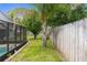 Yard with grass, fence, palm tree, and a screened-in pool area at 10457 Cranston St, Spring Hill, FL 34608