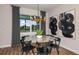 Bright dining area with a round table, modern chandelier, and large windows overlooking the backyard at 11439 Shoreline Trl, Parrish, FL 34219