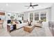 Spacious living room bathed in natural light through large windows, showcasing modern decor and comfortable seating at 11444 Shoreline Trl, Parrish, FL 34219