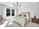 Serene primary bedroom with large windows, a stylish chandelier, and tasteful decor for a peaceful retreat at 11444 Shoreline Trl, Parrish, FL 34219