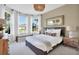Calm and comfortable primary bedroom featuring large windows, soft lighting, and elegant furnishings at 11444 Shoreline Trl, Parrish, FL 34219