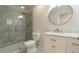 Bathroom with marble-look vanity, round mirror, toilet, and tiled walk-in shower at 11448 Bay Gardens Loop, Riverview, FL 33569