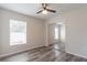 Bedroom with wood-look floors, ceiling fan, window, and mirrored closet doors at 11448 Bay Gardens Loop, Riverview, FL 33569
