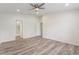 Spacious bedroom with wood-look floors, ceiling fan, and ensuite bathroom at 11448 Bay Gardens Loop, Riverview, FL 33569