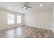 Serene bedroom with wood-look flooring, ceiling fan, and natural light from two windows at 11448 Bay Gardens Loop, Riverview, FL 33569