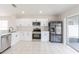 Well-lit kitchen with white cabinetry and stainless steel appliances and fixtures at 11448 Bay Gardens Loop, Riverview, FL 33569