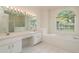 Bright primary bath featuring a double sink vanity, soaking tub, and glass enclosed shower at 1156 Ridgegrove W Dr, Palm Harbor, FL 34683