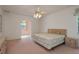 Spacious bedroom with ceiling fan, carpeted floor, and a view of an adjacent sitting area at 1156 Ridgegrove W Dr, Palm Harbor, FL 34683