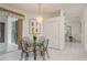 Cozy dining area with glass table, chandelier, and sliding glass doors to the outside at 1156 Ridgegrove W Dr, Palm Harbor, FL 34683