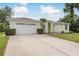 Bright single-story home with an attached garage and a well-maintained lawn at 1156 Ridgegrove W Dr, Palm Harbor, FL 34683
