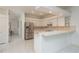 Bright kitchen features white cabinets, stainless steel refrigerator, and a breakfast bar at 1156 Ridgegrove W Dr, Palm Harbor, FL 34683